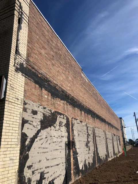 Brick commercial wall with base coat before stucco finish