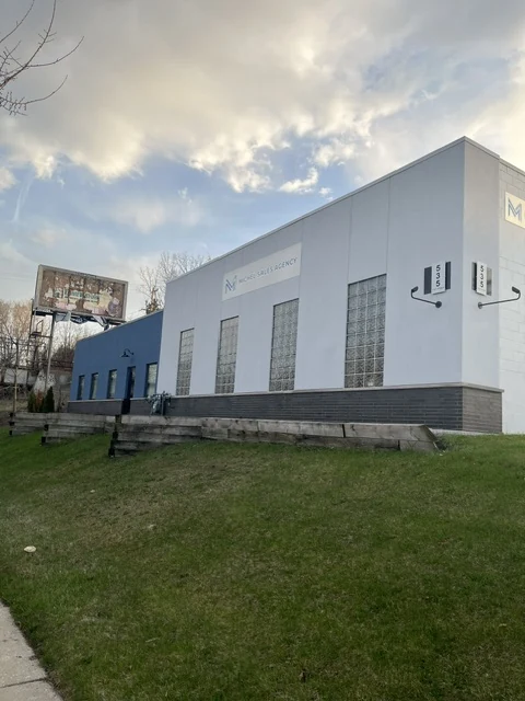 Commercial building with new gray stucco and dark base band