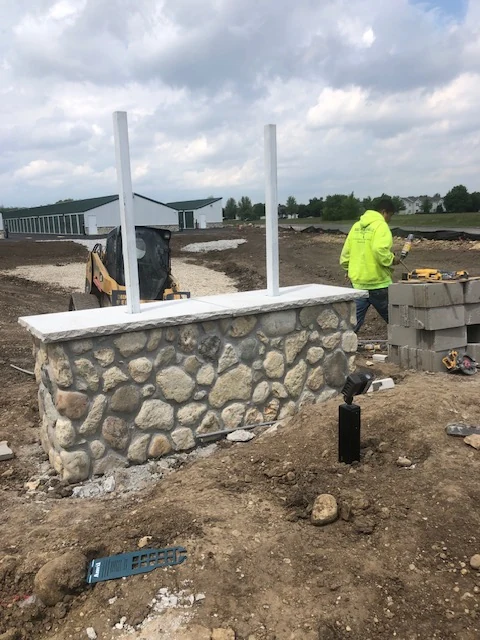 River rock stone veneer wall with a white stone cap
