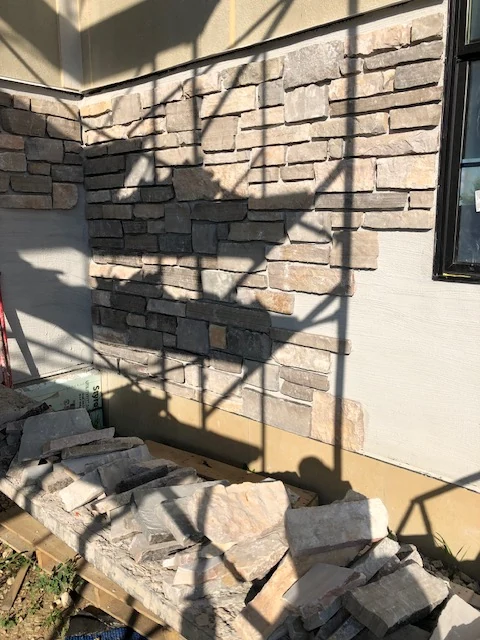 Stacked stone veneer installation on exterior wall